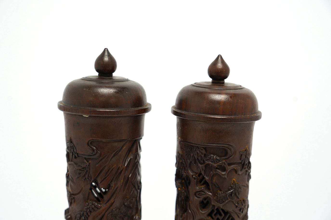 A pair of Chinese hardwood incense holders carved with trees and figures, cased, 29cm high. Condition - good